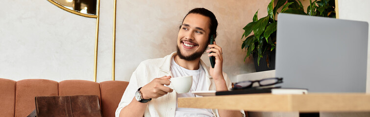 Young man enjoys remote work in a cozy cafe while sipping coffee