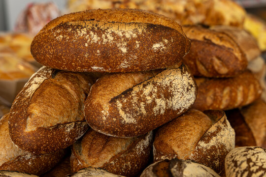 Gros plan sur des pains spéciaux aux farines variées, réalisés par un boulanger artisan avec un savoir-faire traditionnel et des ingrédients de qualité.