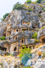 Naklejka premium Demre, Turkey - June 14, 2025:View of the ancient Lycian necropolis and Roman amphitheater in the ruins of Myra, located in Demre, Antalya Province, Turkey.