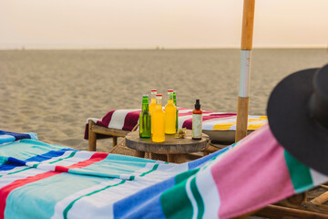Relaxing on beach chairs with drinks and sunscreen at sunset
