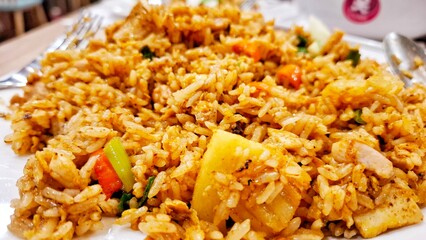 Traditional fried rice with authentic Indonesian spices served on a white plate. A mix of tropical...