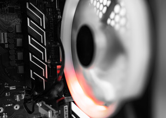 A close-up view of a computer's internal components featuring tangled wires and a glowing cooling...