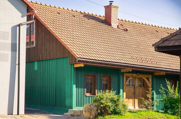 Traditional Rural House with Green Wooden Facade and Tiled Roof