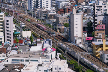 Freight and Commuter Trains Passing Through Dense Urban Rail Lines in Tokyo, Japan