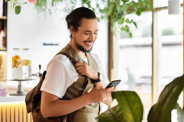 Young man enjoying remote work in a lively cafe during a sunny summer day