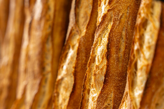 Gros plan sur des baguettes de pain artisanales fraîchement sorties du four, réalisées par un boulanger professionnel.