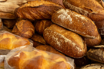 Gros plan sur des pains spéciaux aux farines variées, réalisés par un boulanger artisan avec un savoir-faire traditionnel et des ingrédients de qualité.