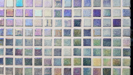 Colorful mosaic tiles reflecting light create a stunning rainbow spectrum highlighting various hues...
