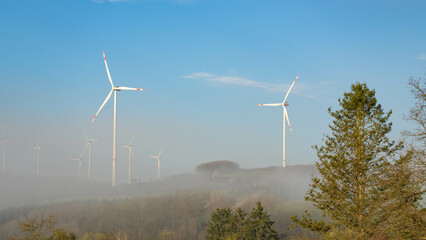 Windwheels in the German Eifel in the morning fog - Summer Energy. High quality photo