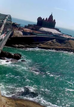A stunning mandapam rests between sea rocks and flowing waves.