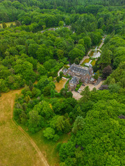 An aerial view of a historic mansion surrounded by lush green trees and a beautifully landscaped...