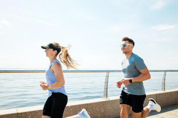 Early morning joggers enjoying a sunny day by the waterfront promenade