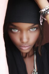 Close-up portrait of woman with striking green eyes, wearing black headscarf