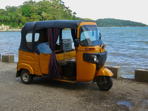 Rickshaw car for transporting people. Motor rickshaw, auto rickshaw, tuk-tuk, mototaxi. Three-wheeled motor scooter.