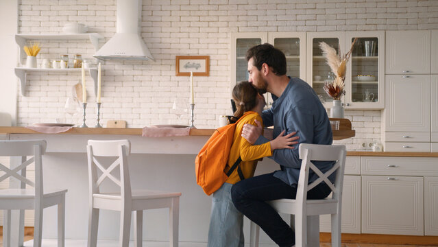 Carefree little Caucasian daughter girl kid run return home from school lessons carrying backpack education father guy man meeting child schoolgirl talk conversation male dad parent family cuddle kiss - Powered by Adobe