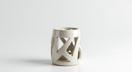 A decorative white ceramic lantern with intricate cut-out patterns, designed to hold a light, isolated on a clean white background.
