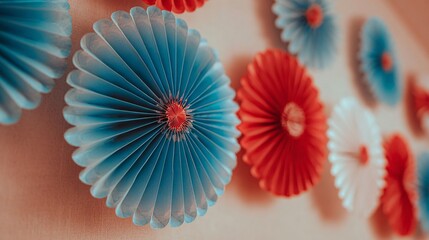 Paper fan decorations in red, white, blue on pale wall, space between