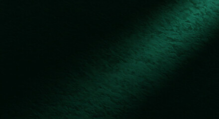 Obraz premium A dark, textured surface illuminated by a diagonal beam of green light, creating a dramatic contrast.