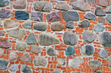 Red brick and large round stones in ancient castle wall
