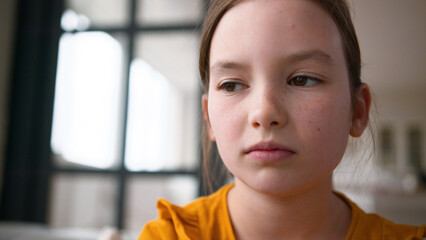 Close up disappointed little Caucasian child girl getting upset frustrated at home. Sad daughter...