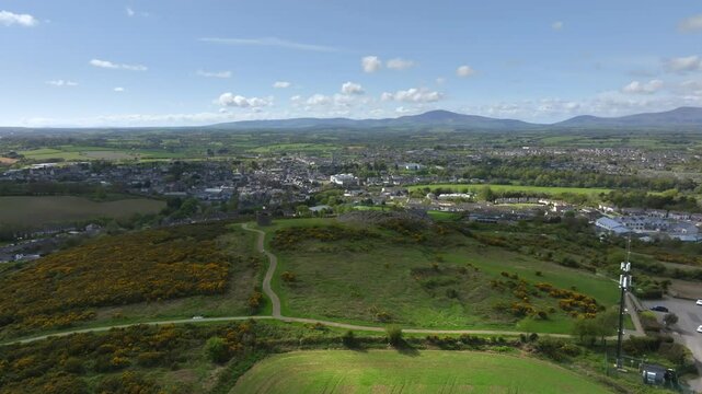 Vinegar Hill, Enniscorthy, County Wexford, Ireland, April 2025. Drone orbit clockwise from parking lot to stone tower monument with flag billowing in wind.