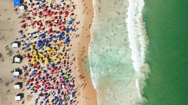 Top-down drone view of Copacabana&rsquo;s colorful umbrellas and surf along Rio&rsquo;s sunny coastline