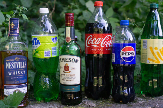 Bratislava, Slovakia, Europe - Jul 07, 2025: a line of assorted alcoholic beverages and soft drinks, including nestville whisky, jameson whiskey, fanta, coca cola, and pepsi, sitting outdoors