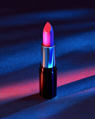 Vibrant lipstick with neon pink and electric blue hue stands prominently against textured background, illuminated by dramatic lighting that enhances its glossy finish. striking colors create
