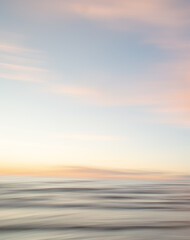 A dreamy, impressionistic paint like blurred sea sunset background with gently soft pastel colours....