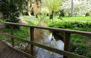 Wooden bridge over a small creek in a beautiful garden in springtime