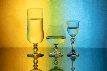 Three glass goblets on a colored gradient background