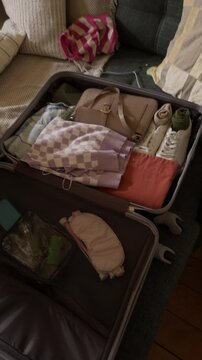 Vertical UGC footage of unrecognizable person filming vlog while giving pill bottle to teenage African American girl packing suitcase at home
