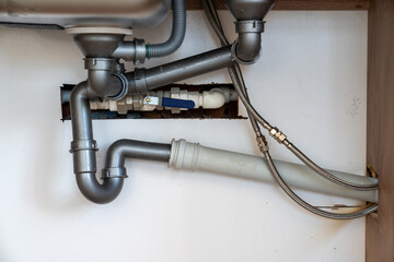 Close up view of  faucet drain, pipes, connections.