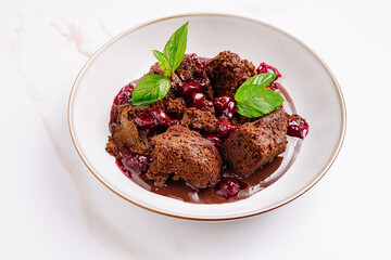 Delicious chocolate cake with cherry sauce and mint garnish served elegantly