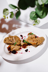 A refined appetizer featuring creamy duck liver pate paired with slices of rustic artisan bread,...