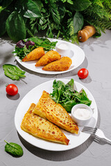 Delicious savory dishes served with fresh greens and dipping sauce