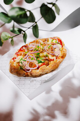 Freshly baked flatbread topped with vegetables and onions on display