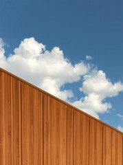 A contemporary wooden structure against a bright blue sky with fluffy white clouds.