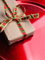 Christmas gift in natural wrapping paper on a red background