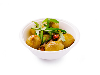 Delicious olives with herbs served in a white bowl at a food market