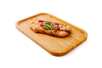 Freshly baked flatbread topped with herbs and red vegetables on wooden tray