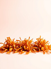 Vibrant orange abstract floral arrangement on a soft pastel background, showcasing creative design.