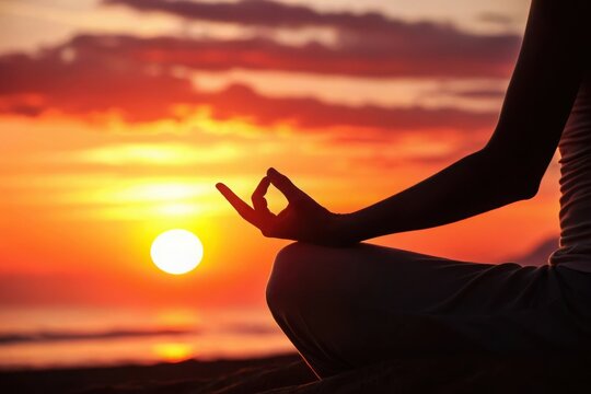 Silhouette of a person meditating peacefully on a beach at sunset