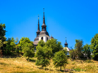 Scenic Church with Twin Spires on the hillside surrounded by Greenery