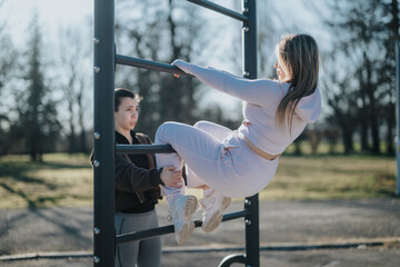 Outdoor workout in a park featuring two people using equipment during a fitness session on a sunny...