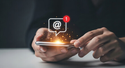 Hands hold phone, displaying email notification with glowing particles.  Illustrates digital communication and new message alert