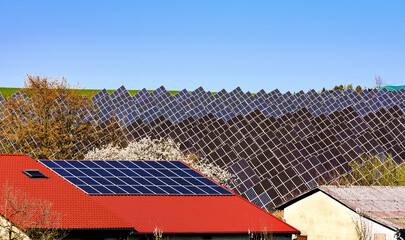 Rotes Hausdach mit Solarzellen vor Solarfarm