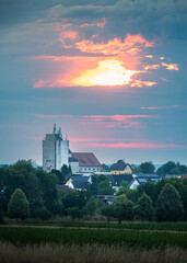 Modern industrial silos against a sunrise sky with architectural details