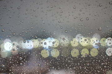 Rain Drops on Window with Night Light Bokeh Background
