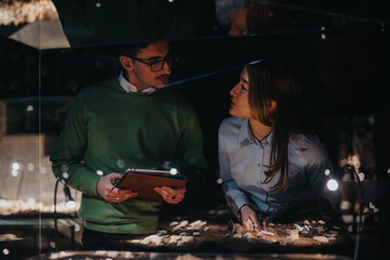 Two people examining artifacts in a museum exhibit under focused lighting, capturing a moment of...